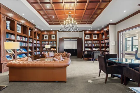 a living room with furniture a bookshelf and a chandelier