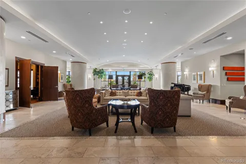 a living room with furniture and a dining table with kitchen view