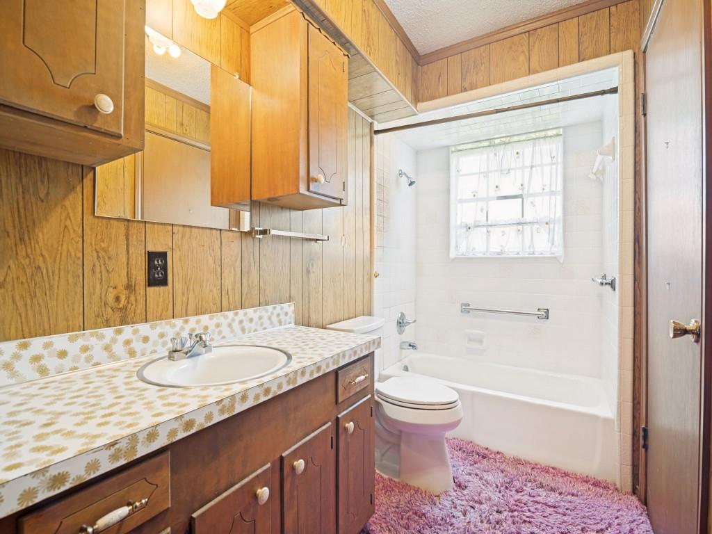 1081 Wright Street Terrell, TX 75160 - Photo 17 of 29 Bathroom featuring a built-in vanity with a drop-in sink and a patterned countertop