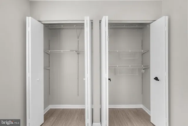 a view of walk in closet with wooden floor