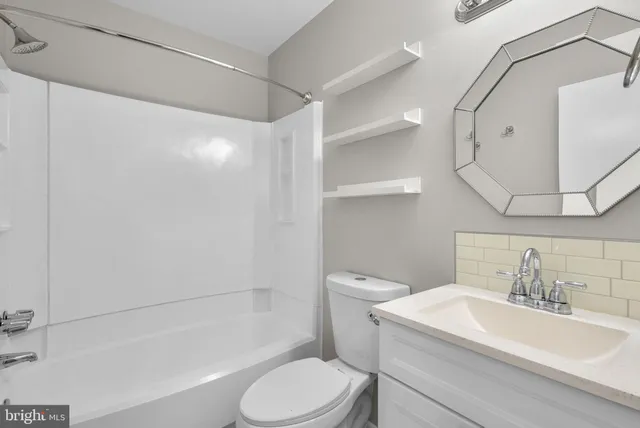 a white toilet sitting next to a bathroom sink and tub