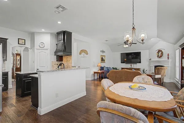a living room with furniture kitchen view and a chandelier