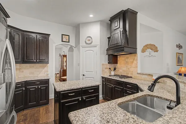 a kitchen with stainless steel appliances granite countertop a sink stove and refrigerator