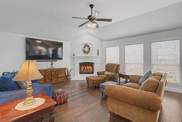 a living room with furniture a fireplace and a flat screen tv