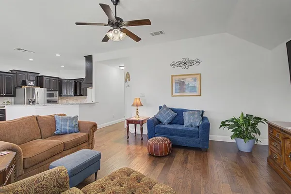 a living room with furniture and a wooden floor