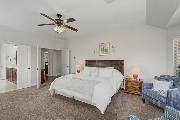 a spacious bedroom with a bed and a chandelier