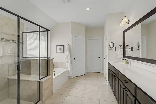 a spacious bathroom with a granite countertop sink mirror and bathtub