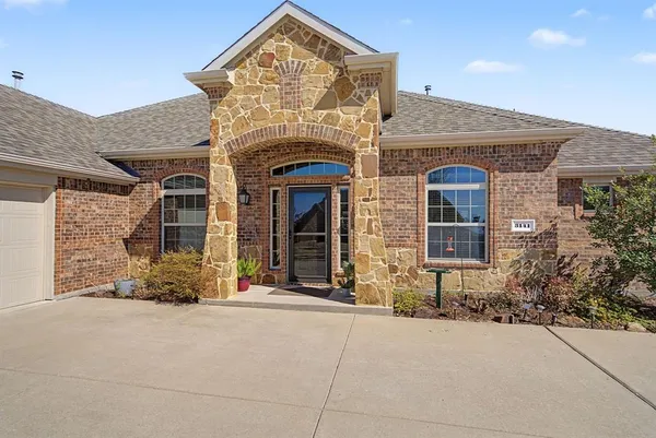 front view of a brick house with a small yard
