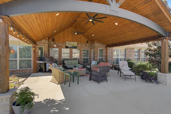 a view of a patio with couches table and chairs and potted plants