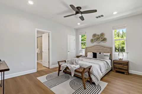 a bedroom with a bed a couch and a large window