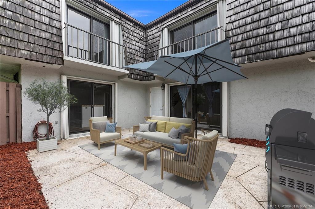 a view of a patio with couches table and chairs and potted plants