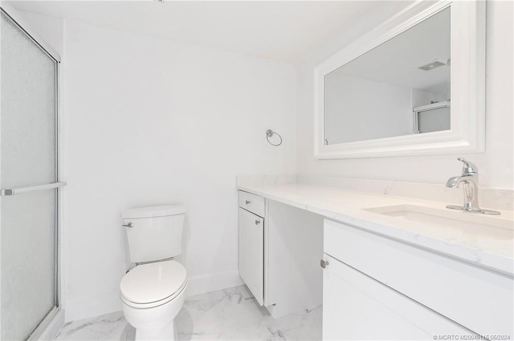 762 Northwest 10th Terrace Stuart, FL 34994 - Photo 27 of 41 a bathroom with a granite countertop sink mirror vanity and toilet