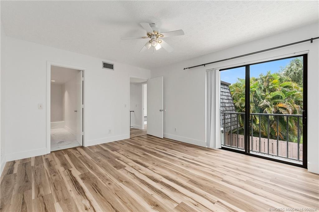 762 Northwest 10th Terrace Stuart, FL 34994 - Photo 31 of 41 a view of a room with wooden floor and a ceiling fan
