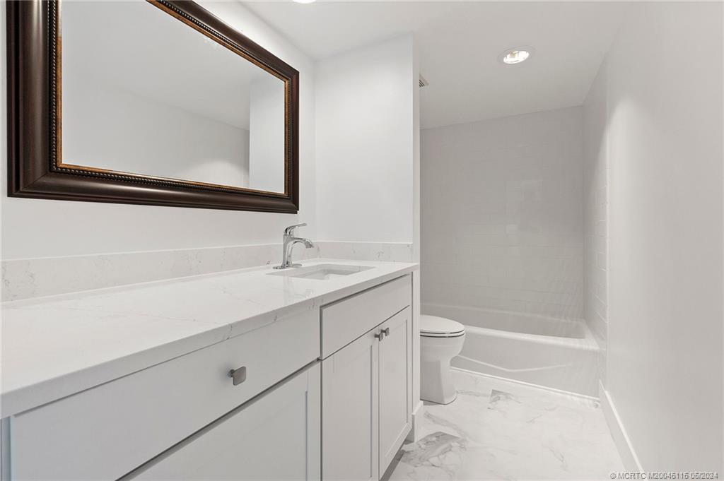 762 Northwest 10th Terrace Stuart, FL 34994 - Photo 33 of 41 a bathroom with a toilet a sink and mirror