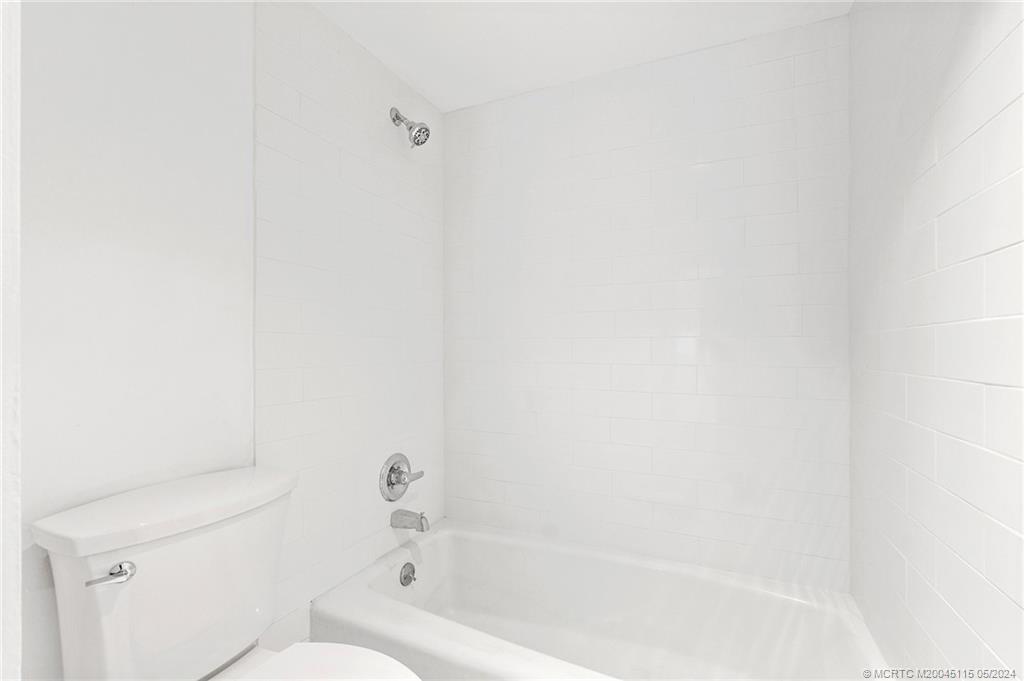 762 Northwest 10th Terrace Stuart, FL 34994 - Photo 34 of 41 a bathroom with a bathtub and a toilet