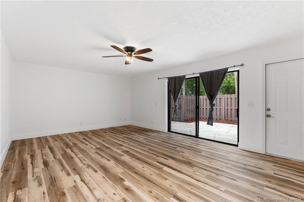 762 Northwest 10th Terrace Stuart, FL 34994 - Photo 9 of 41 a view of empty room with wooden floor and fan