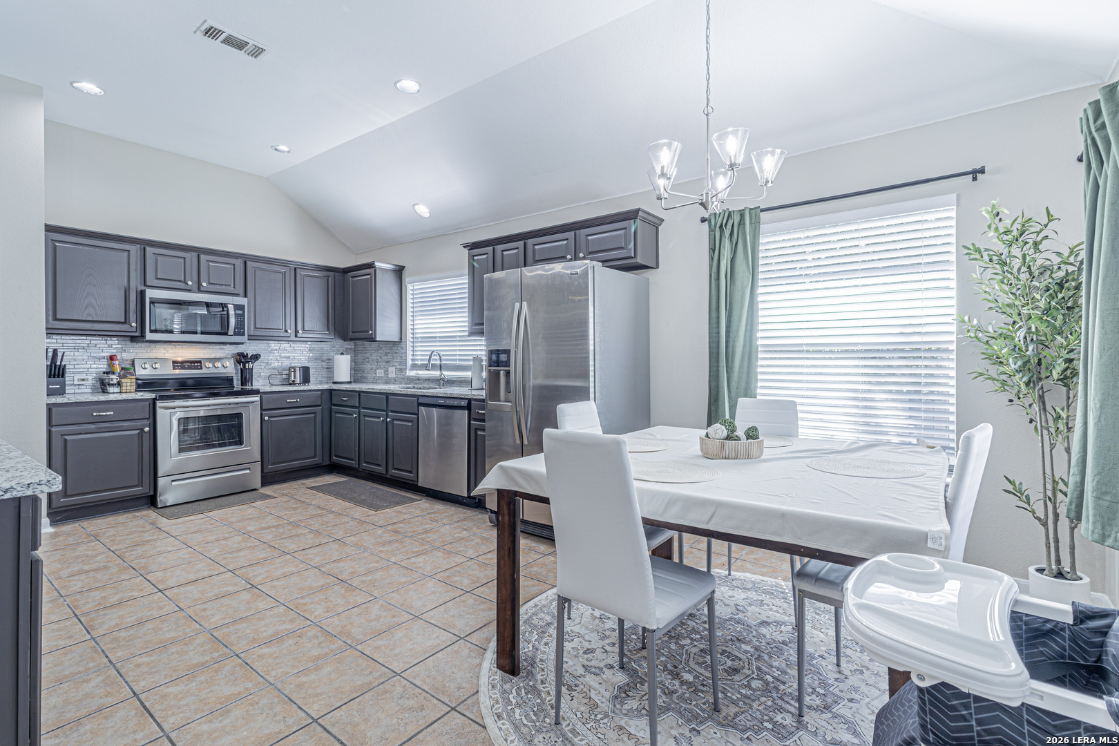 1815 Indian Paint Brush Road San Antonio, TX 78232 - Photo 18 of 35 a kitchen with a table chairs refrigerator and cabinets