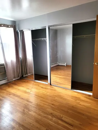 an empty room with wooden floor and entrance