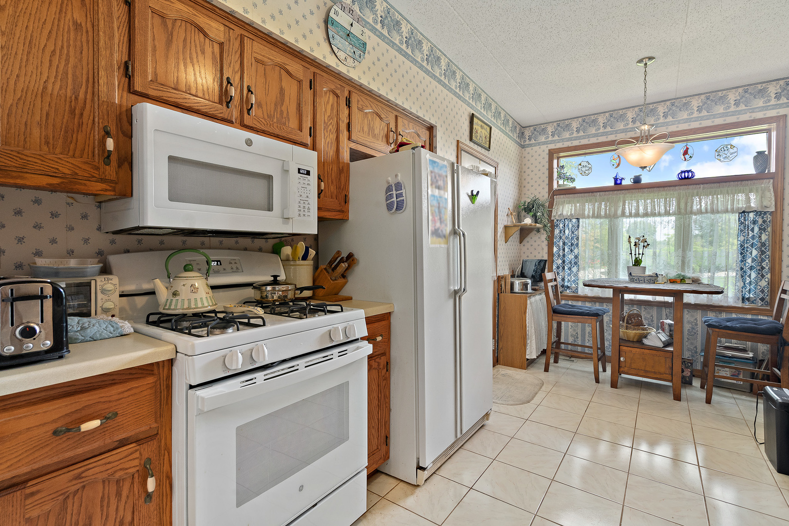 18431 Pine Cone Drive, Unit 1 Tinley Park, IL 60477 - Photo 7 of 33 a kitchen with stainless steel appliances granite countertop a stove a sink and a refrigerator