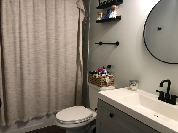 a bathroom with a sink a toilet and shower curtain
