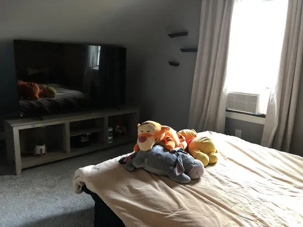 a bed sitting in a bedroom with tv