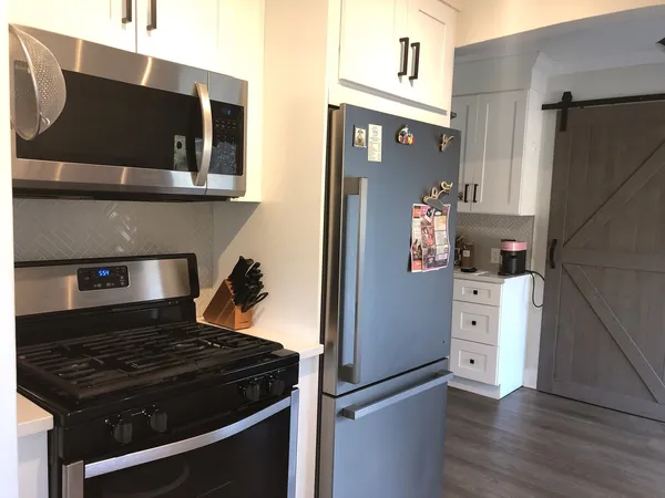 a kitchen with a refrigerator and a stove top oven