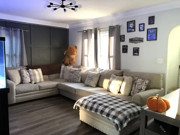 a living room with furniture and painting on the wall