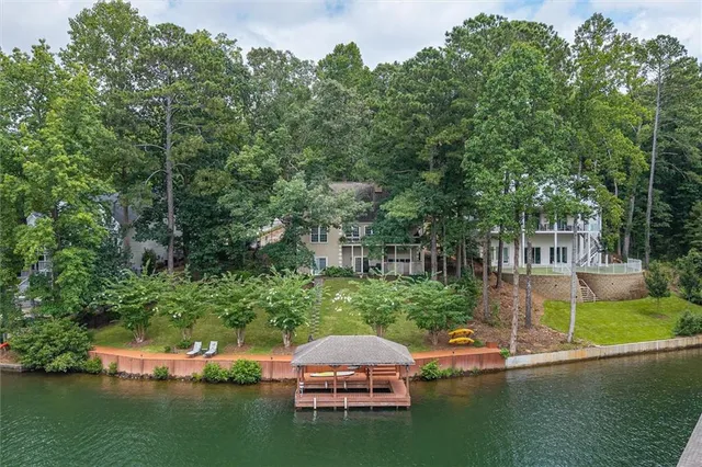 an aerial view of a house with swimming pool a yard and lake view