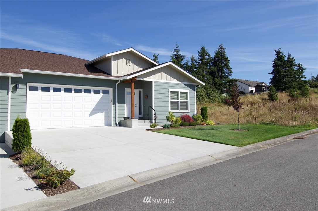 161 Stratus Loop Sequim, WA 98382 - Photo 1 of 34 a front view of a house with a yard and garage