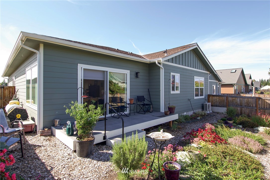 161 Stratus Loop Sequim, WA 98382 - Photo 15 of 34 a house with lots of potted plants and a bench