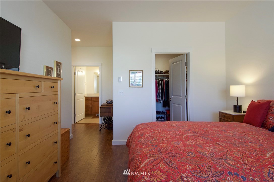 161 Stratus Loop Sequim, WA 98382 - Photo 21 of 34 a bedroom with a bed and wooden floor
