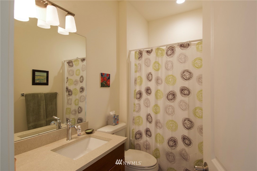 161 Stratus Loop Sequim, WA 98382 - Photo 26 of 34 a bathroom with a sink toilet a mirror and shower curtain