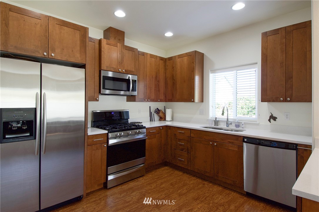 161 Stratus Loop Sequim, WA 98382 - Photo 8 of 34 a kitchen with a sink a microwave a refrigerator and cabinets