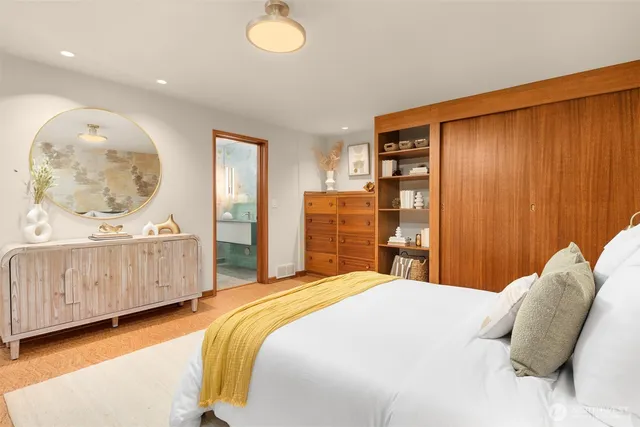 a bedroom with a bed mirror and window