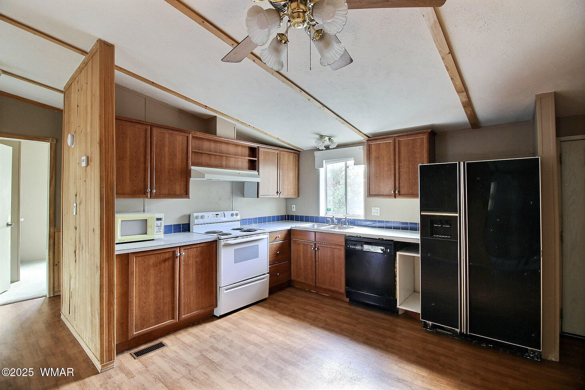 7803 Stokes Lane Show Low, AZ 85901 - Photo 4 of 25 a kitchen with stainless steel appliances granite countertop a refrigerator a sink dishwasher a stove and a dining table with wooden floor