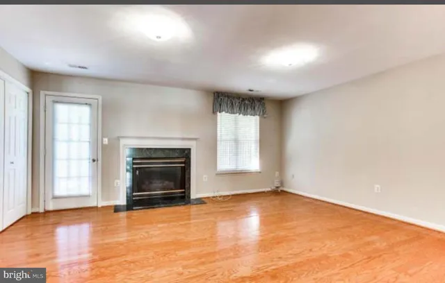 an empty room with a fireplace and windows