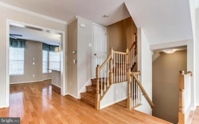 a view of a hallway with wooden floor and windows