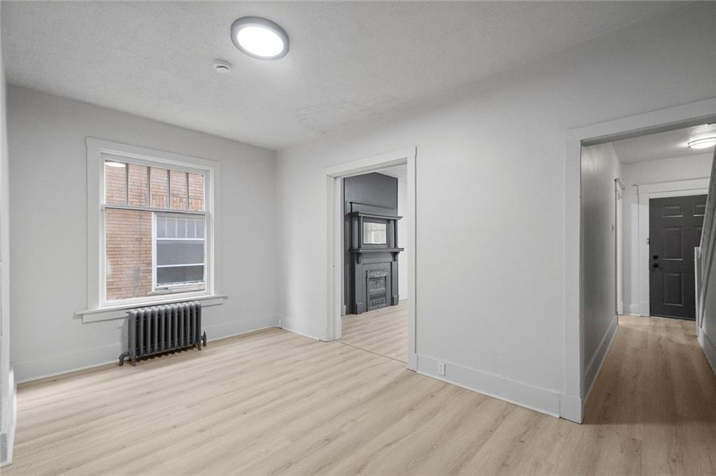 306 Park Road Ambridge, PA 15003 - Photo 6 of 43 an empty room with wooden floor and windows