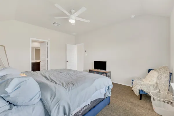 a spacious bedroom with a bed and a chandelier