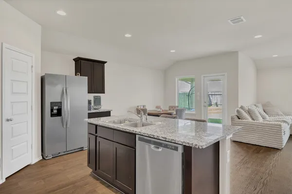 a kitchen with stainless steel appliances granite countertop a sink and refrigerator