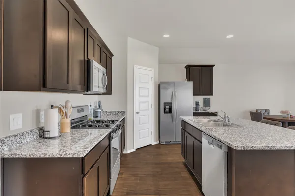 a kitchen with stainless steel appliances granite countertop a sink stove and refrigerator