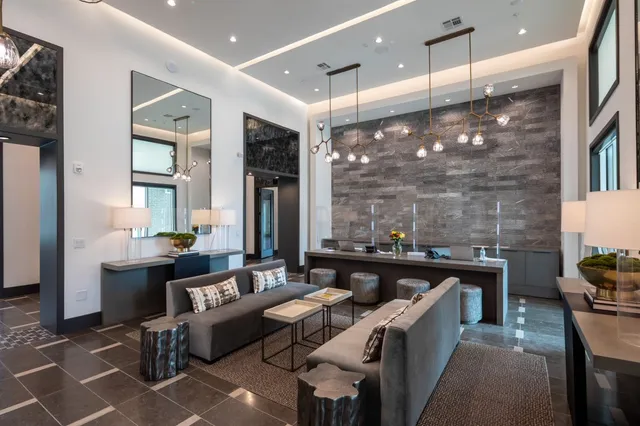 a living room with furniture a large window and stainless steel appliances