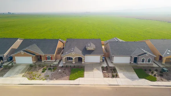 an aerial view of residential houses with outdoor space and swimming pool