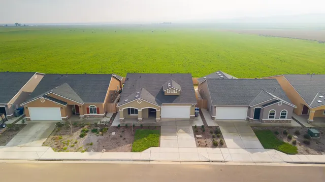 an aerial view of residential houses with outdoor space and swimming pool