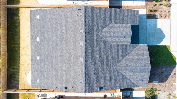 an aerial view of a house with a backyard space