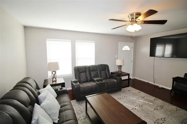 a living room with furniture and a ceiling fan