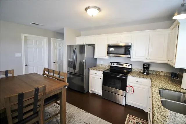 a kitchen with a table chairs stove and refrigerator