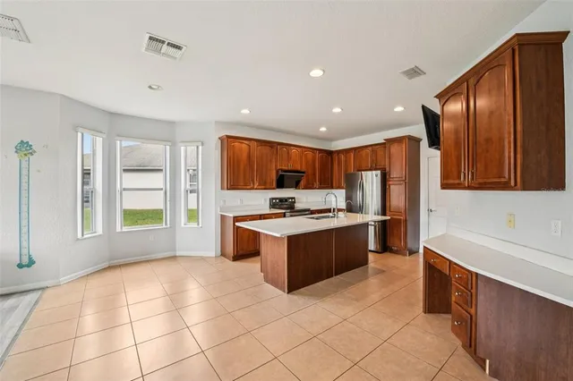 a large kitchen with stainless steel appliances granite countertop a stove a sink and a refrigerator