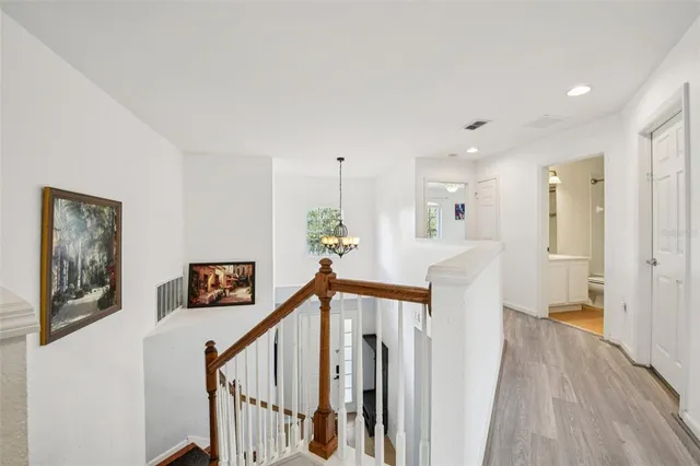 a view of a hallway with wooden floor and stairs