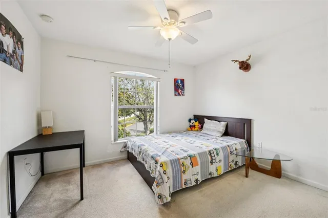 a bedroom with a bed chandelier and a window